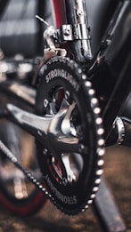 A close-up view of a bicycle drivetrain featuring a chainring and crank arm. The metal components have a sleek and polished appearance, with the brand name 'STRONGLIGHT' visibly etched onto the black chainring.