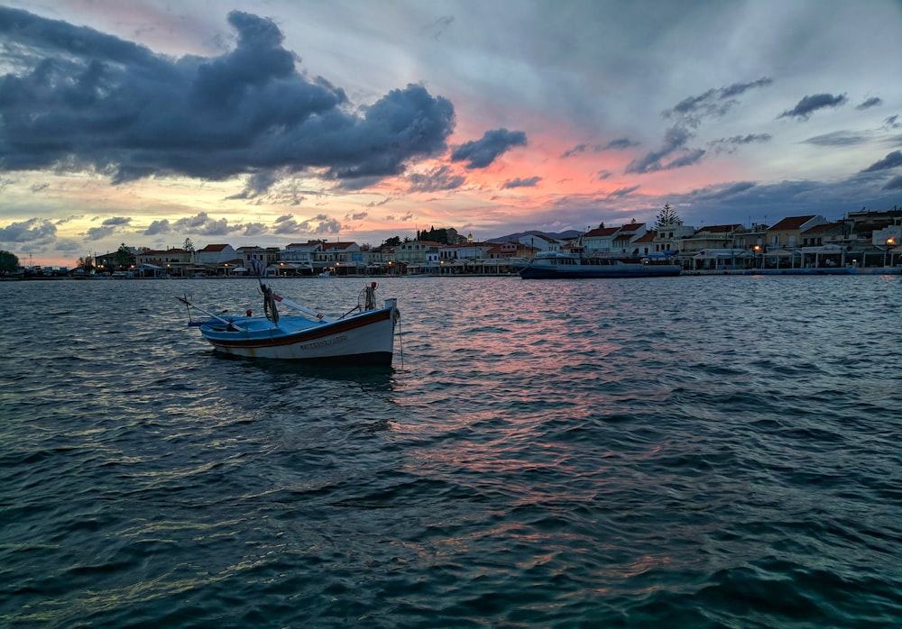 white boat on body of water during sunset