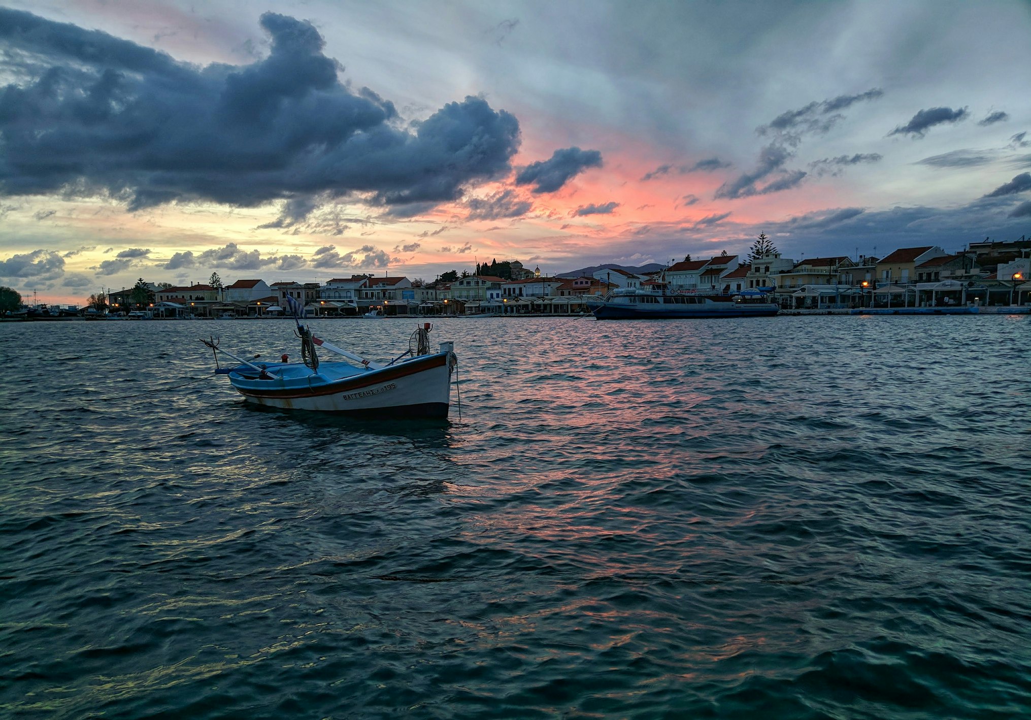 Una barca solca il mare di Samos al crepuscolo