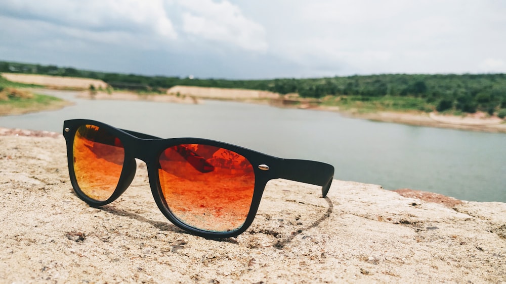 a pair of sunglasses sitting on top of a rock