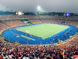 The new Flamengo stadium glowing under night lights filled with cheering fans.