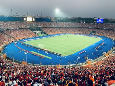 The new Flamengo stadium glowing under night lights filled with cheering fans.