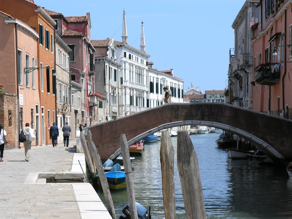 people walking on bridge and near water canal