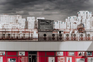 Close-up of a used AC compressor with a price tag, set against a backdrop of a city skyline.