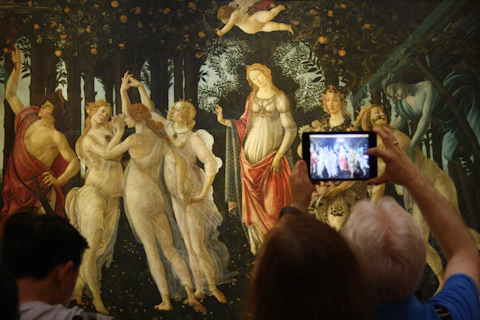 person taking a picture of a dancing women and men painting