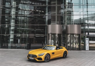 yellow convertible coupe near building