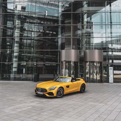 yellow convertible coupe near building