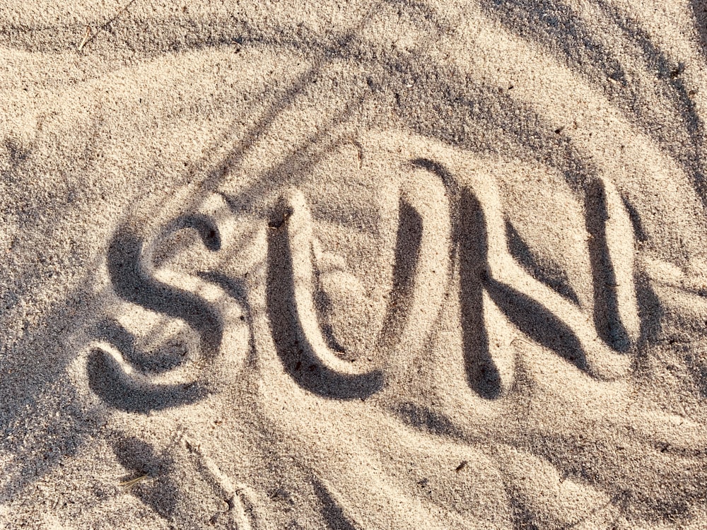 brown sand Sun writing
