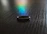 Close-up of a matte black Zeneio smart ring glowing softly on a dark surface.