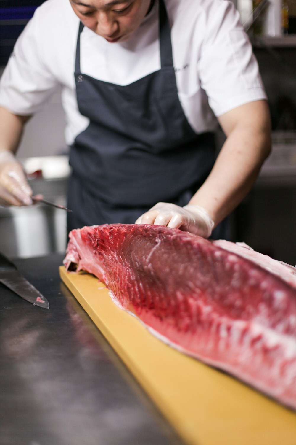 persona cortando carne de pescado cruda