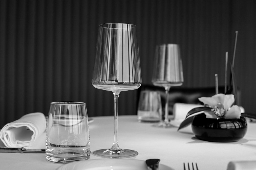 grayscale photo of drinking glass on table