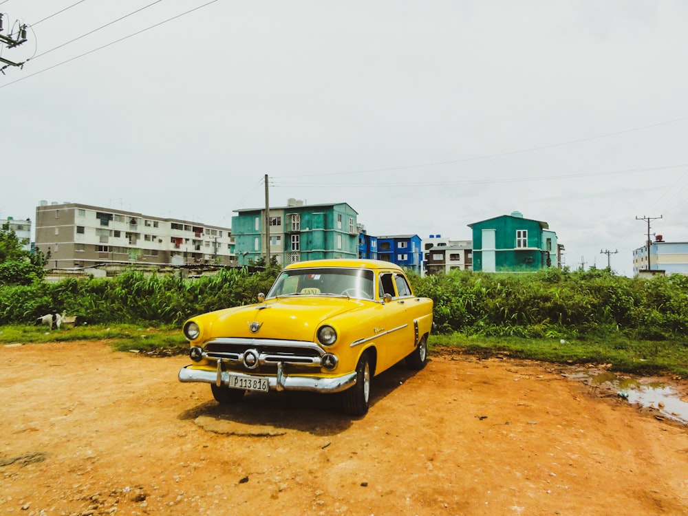 yellow sedan parked near plants