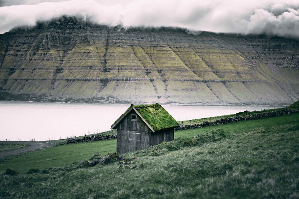 Maison en bois gris près d’un champ vert