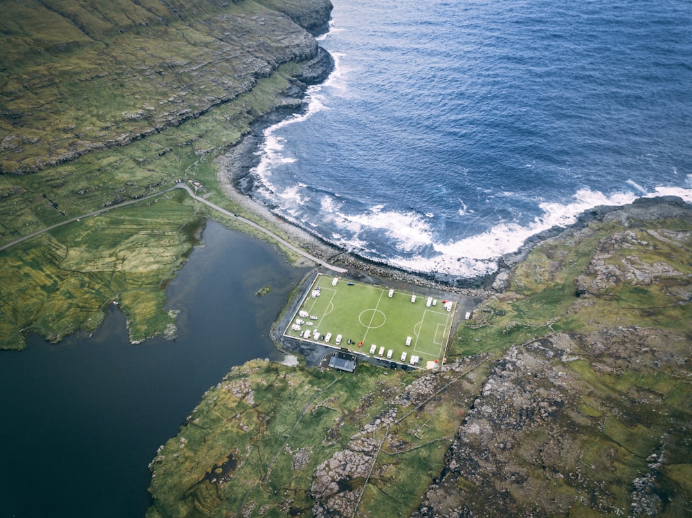 aerial photo of soccer field near body of water during daytime