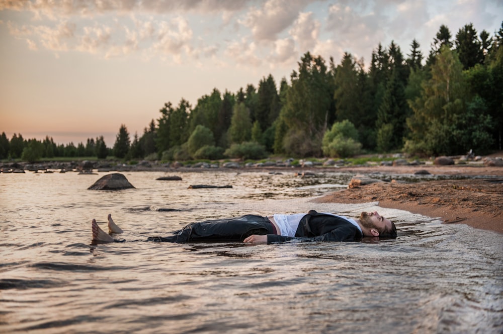 person lies in body of water