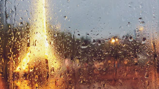 A calm window view showing a cityscape blurred by rain, evoking feelings of distance and introspection.