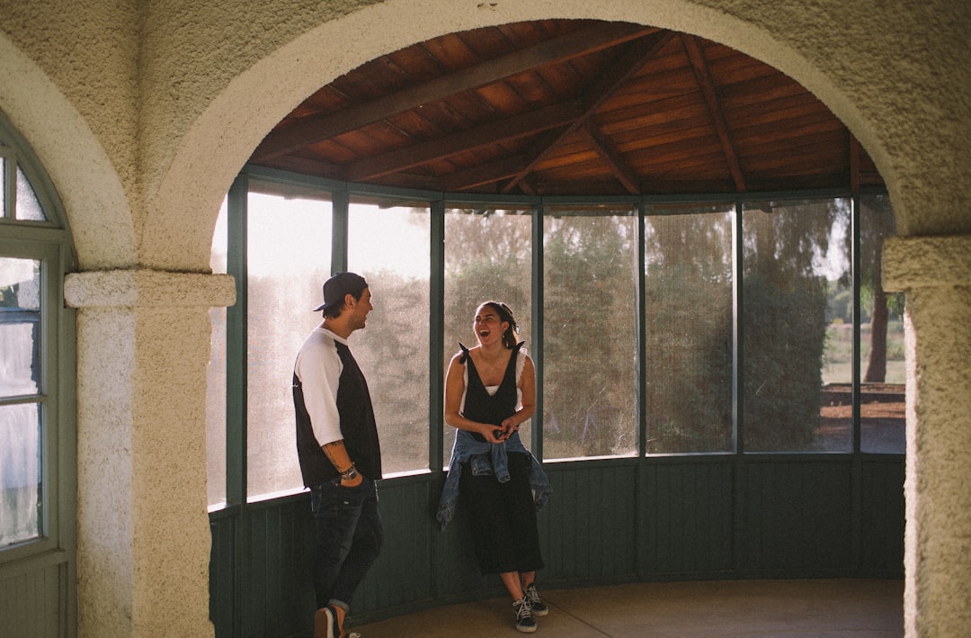 man and woman on front of clear glas window