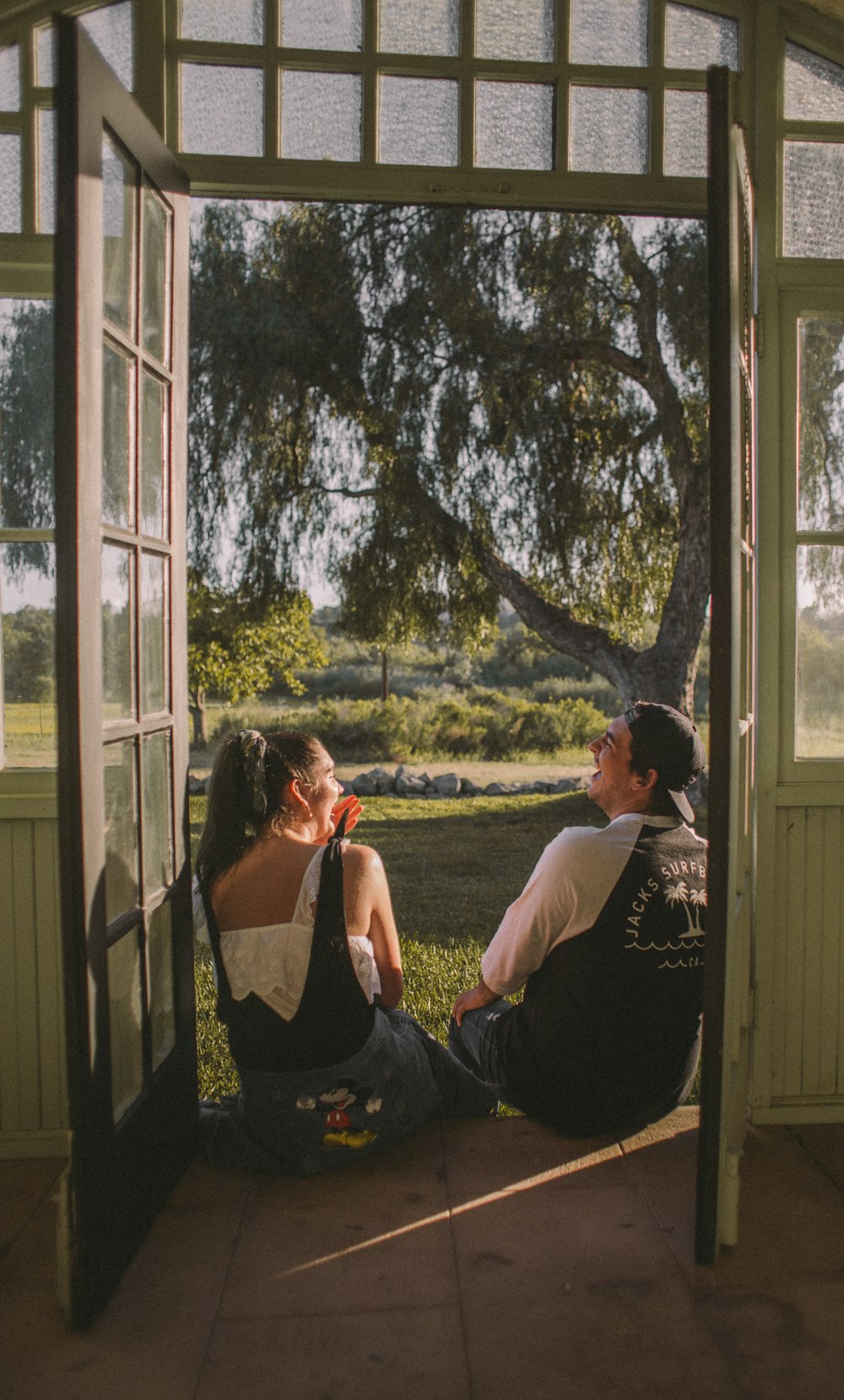 Frau und Mann sitzen in der Nähe der geöffneten Tür