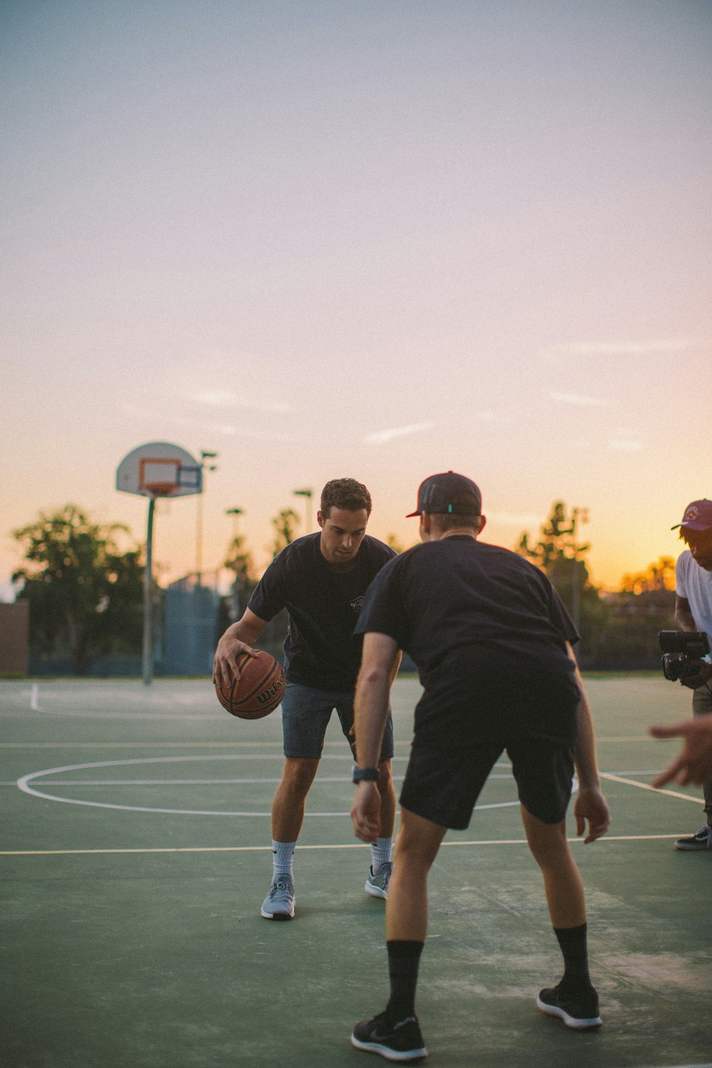 two guy playing basketball during daytime