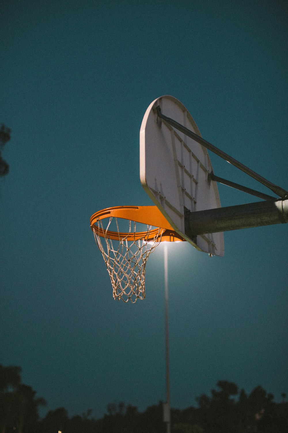 flaches Fokusfoto eines weißen und orangefarbenen Basketballkorbs