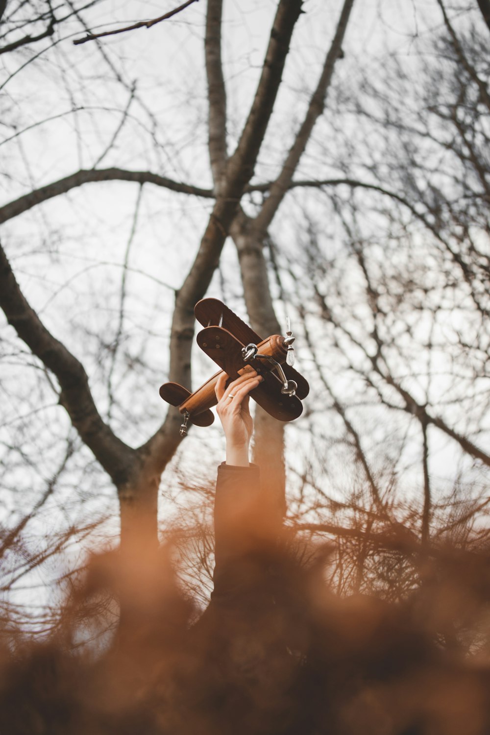 person holding brown biplane toy