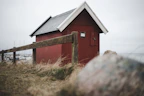 A weather-resistant wendy house used as a secure storage unit near the coast.