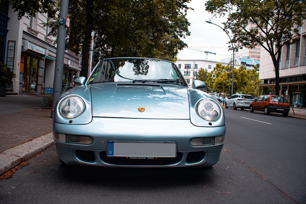 blue vehicle parked on road at daytime