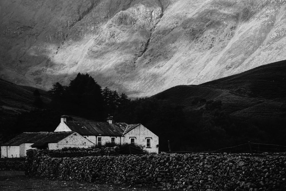 a black and white photo of a house in the mountains