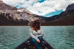 woman in gray sweater sitting on boat and looking on her left side