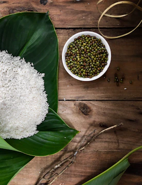 Bright green moong dal grains spread on a rustic wooden table.