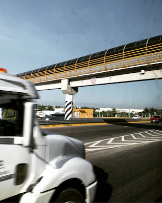 TrustHaul Logistics truck crossing a modern bridge with city skyline in the background.