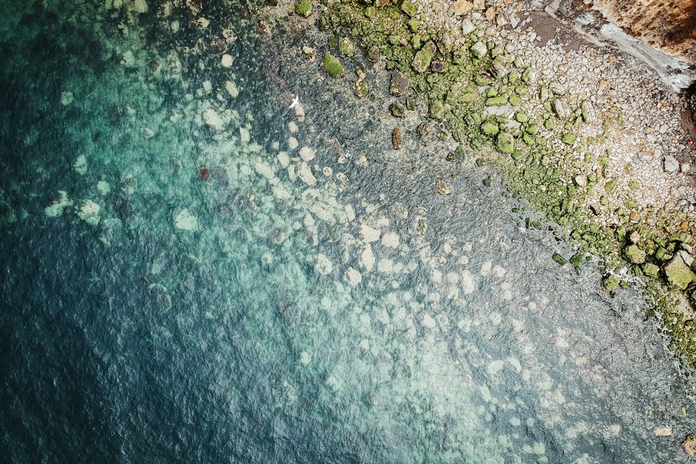 pietra vicino allo specchio d'acqua durante la fotografia diurna con vista dall'alto