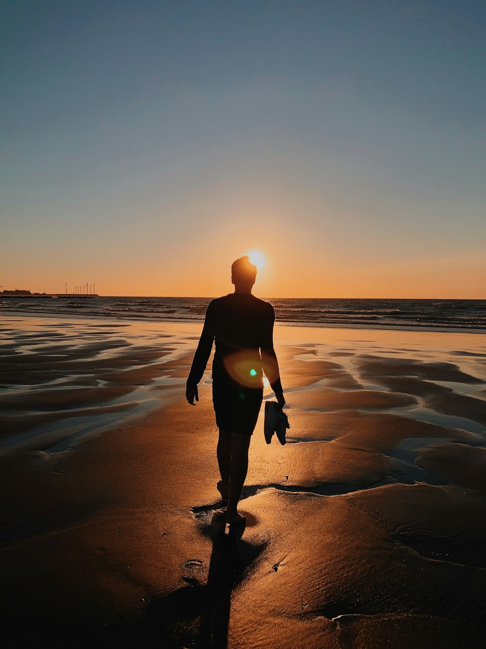 silhouette of person standing on shore