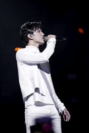 Levan Tabukashvili performing passionately on stage in an elegant opera costume under dramatic lighting.