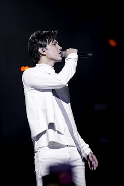 Levan Tabukashvili performing passionately on stage in an elegant opera costume under dramatic lighting.