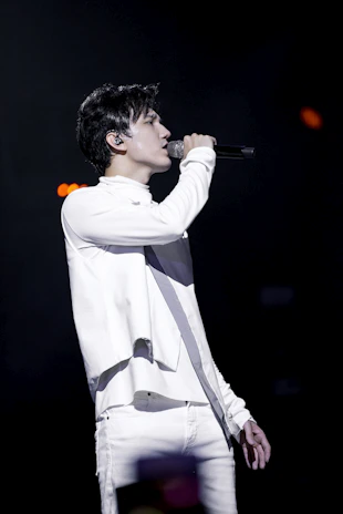 Connor Dapkus singing passionately on stage with a subtle gold-accented costume.