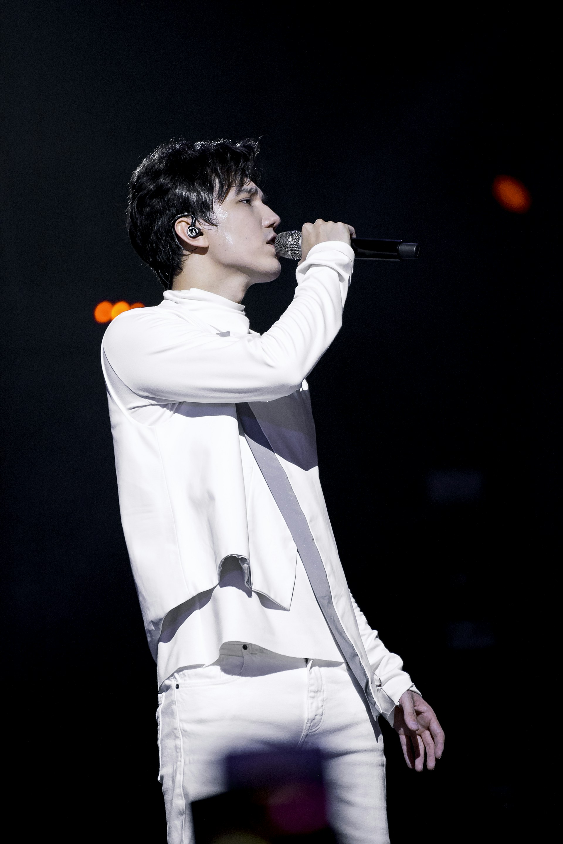 Dannah performing passionately on stage with a spotlight highlighting her expressive face.