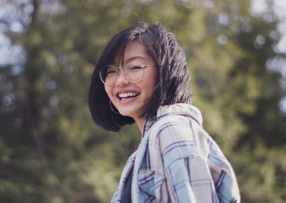 woman in blue and black checked collared shirt smiling