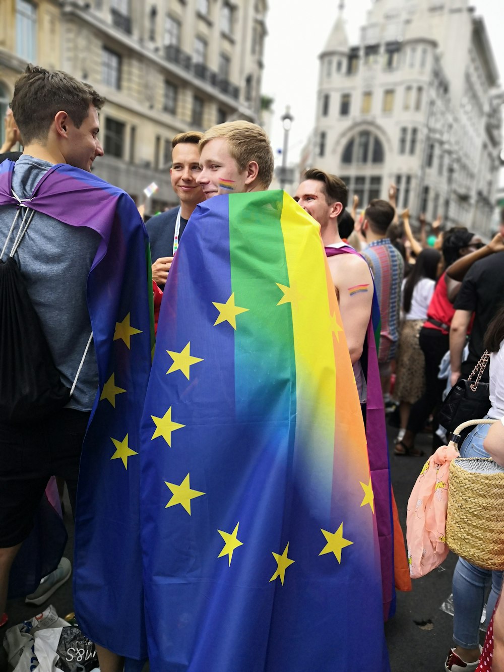 a group of people standing next to each other holding a rainbow flag