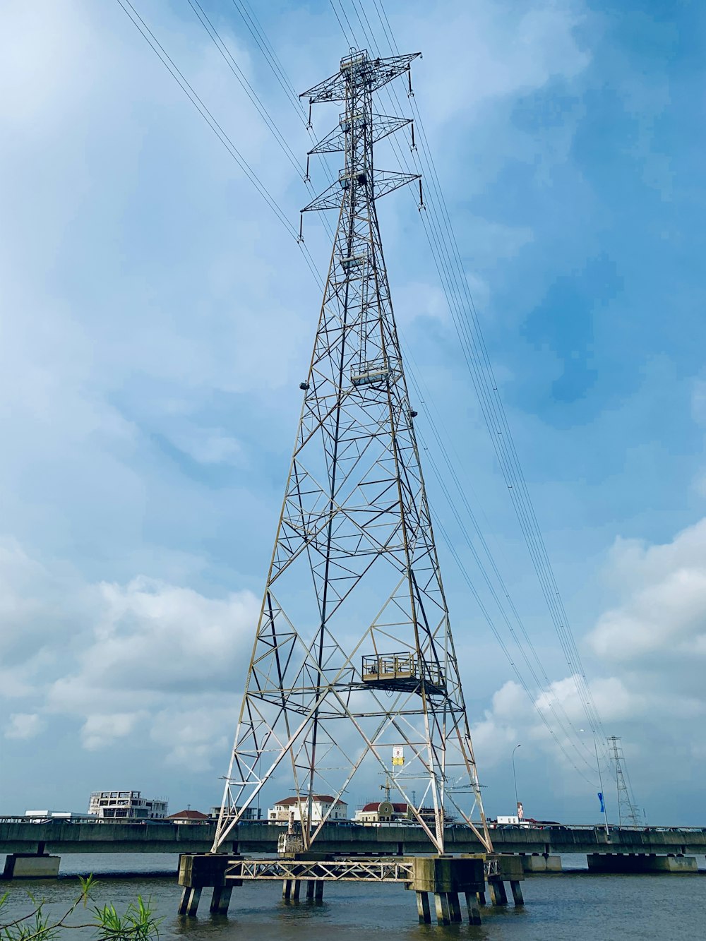 Torre de transmisión de metal gris en cuerpo de agua