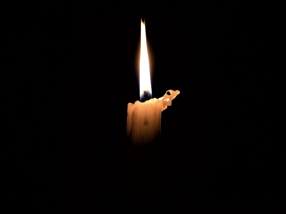 yellow taper candle with black background