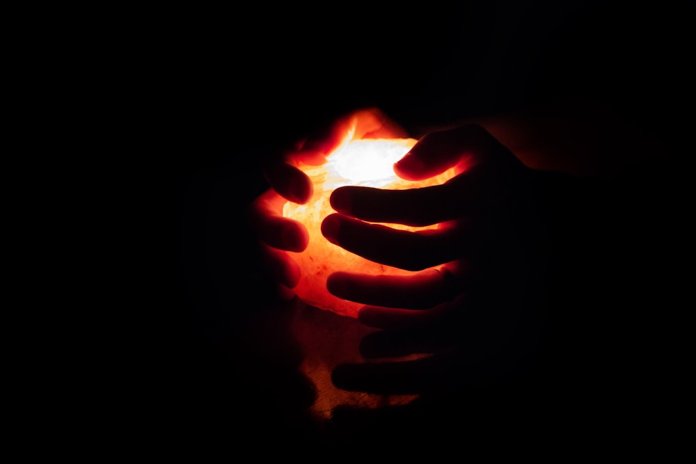 a person holding a lit candle in their hand