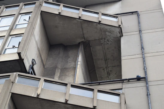 A detailed view of Wisma Equity's brutalist facade highlighting its architectural lines and urban presence.