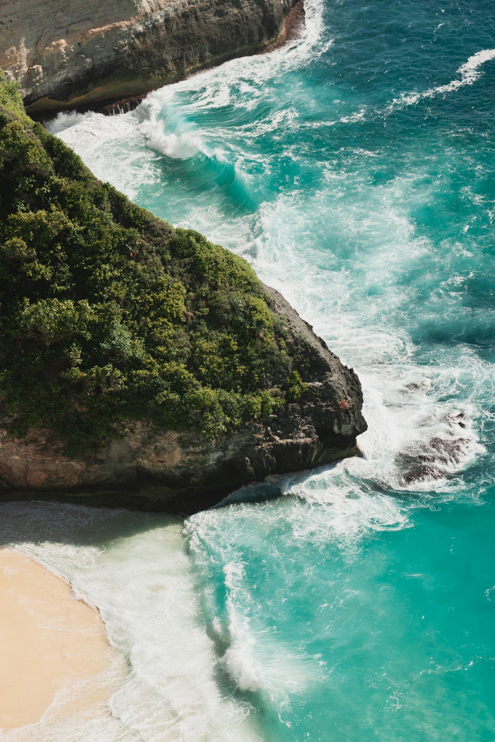 Fotografia aerea delle onde che si infrangono sulla riva del mare durante il giorno