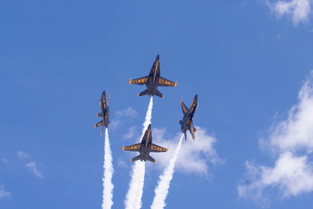 four jet planes under blue sky