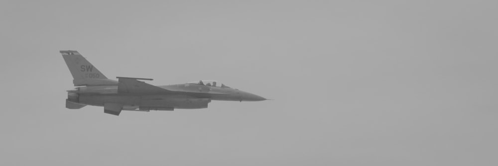 a fighter jet flying through a foggy sky