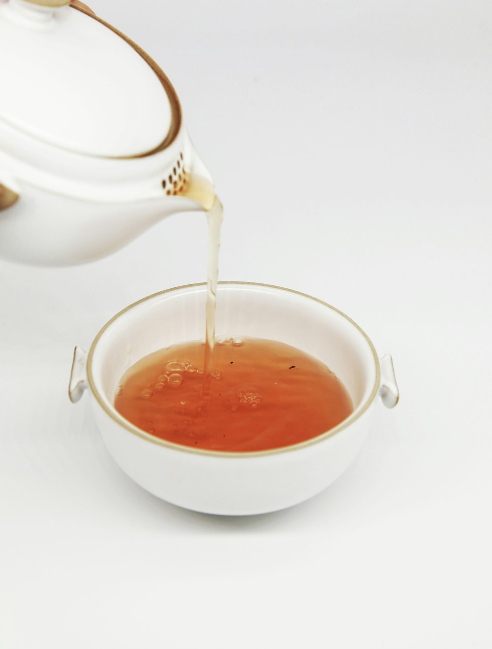 El té se vierte en una taza de té blanca