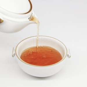 tea pours into white teacup