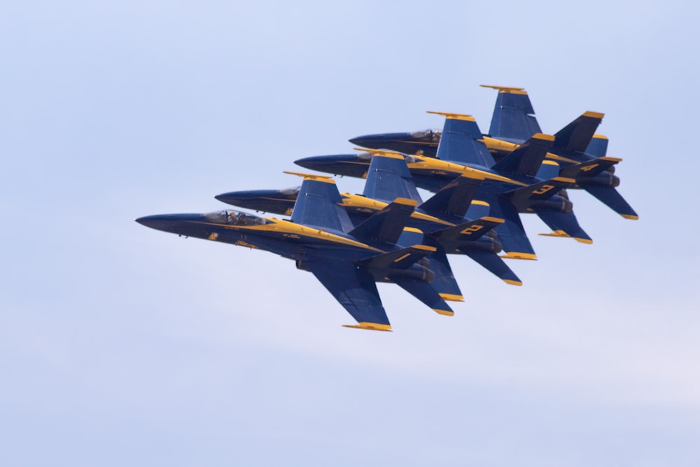 four blue-and-yellow fighter jets on the sky