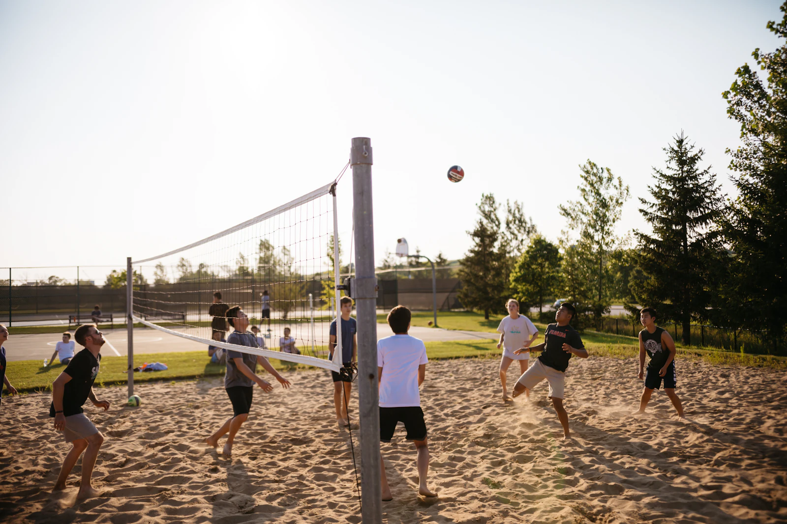 Coworkers playing a casual game of beach volleyball on a sandy court